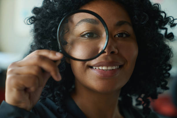 istock Smiling multiracial woman looking through magnifying glass 1417915461