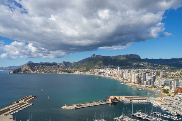 cielo nuvoloso e il porto turistico di calpe sulla costa mediterranea in spagna - benidorm alicante spain headland foto e immagini stock