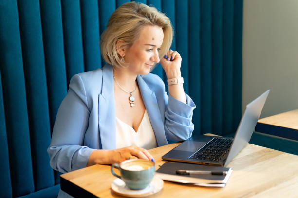 femme d’affaires. face belle caucasien jeune ou mûre carrière professionnelle femme patron en costume d’affaires travaillant sur ordinateur portable. femmes entrepreneures modernes travaillant dans une petite entreprise de restauration et de café - restaurant business person setting the table clothing photos et images de collection