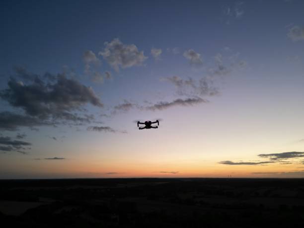 istock Quadcopter drone hovering in the sunset sky 1417918334
