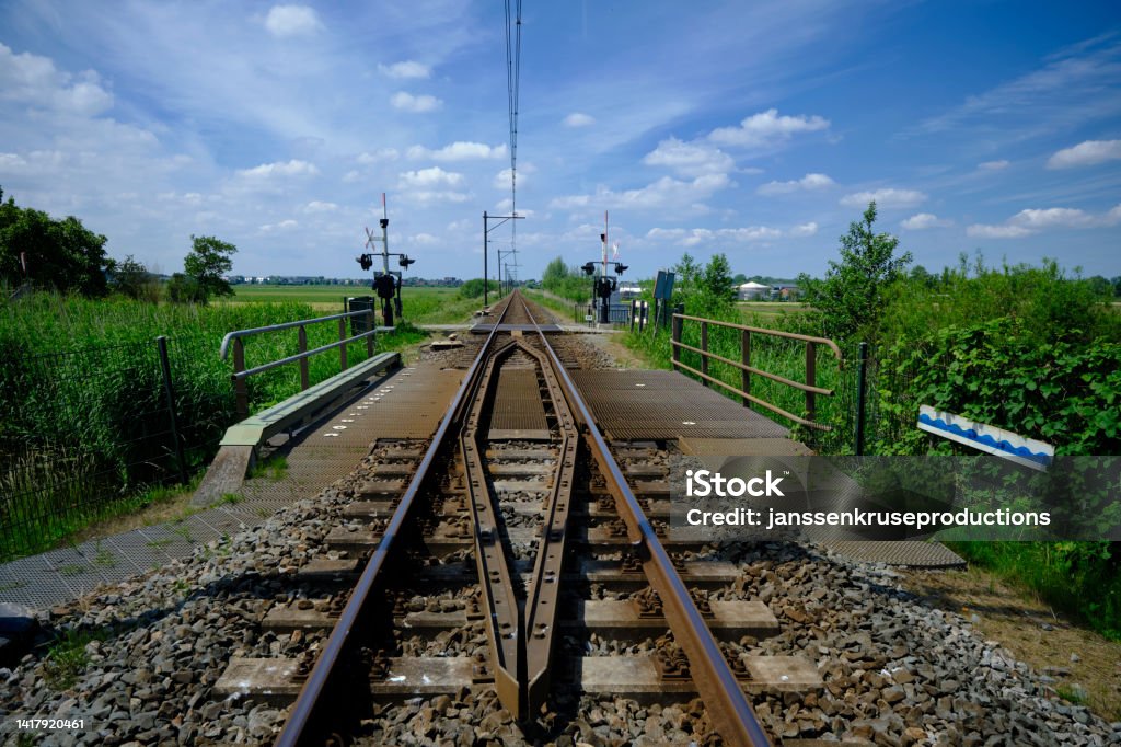 railroad crossing between the meadows in the Netherlands Blue Stock Photo