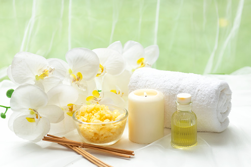 Thai Spa Treatments aroma therapy salt and nature green sugar scrub massage with orchid flower on wooden white with candle. Thailand. Healthy Concept