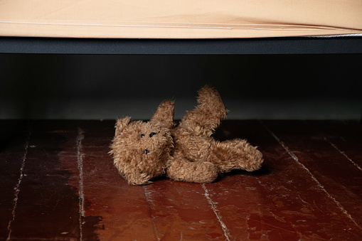 Cute brown teddy bear doll sitting with white wall background copy space. Children toy, learning concept.