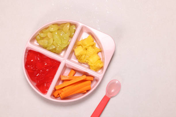 Baby Food Weaning Baby Food weaning led. Steamed carrots mango quartered grapes and jelly. High resolution image 45Mp taken with Canon EOS R5 with f2.8 Macro Lens feeding grapes stock pictures, royalty-free photos & images