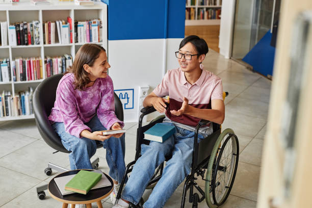 junge studentin mit behinderung in der college-bibliothek - accessability stock-fotos und bilder