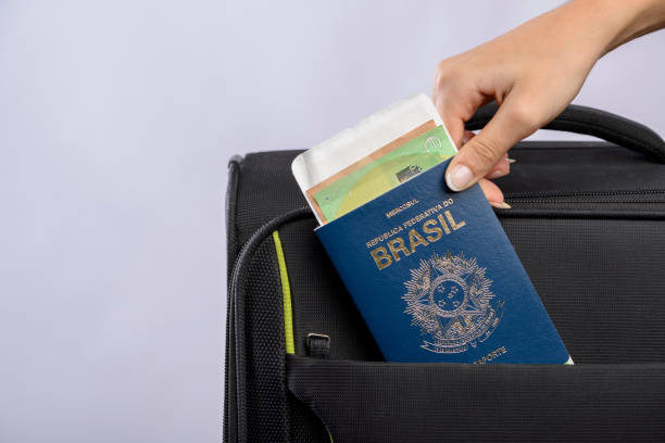 Brazilian passport being placed in the suitcase. stock photo