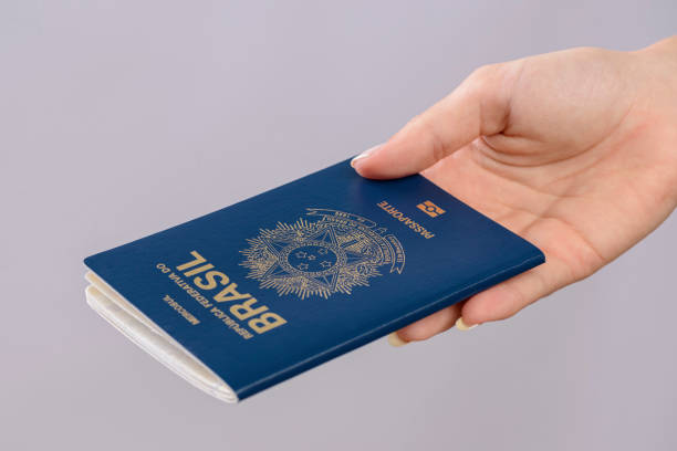 istock Brazilian passport in a hand with white background. 1417922705