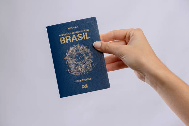istock Brazilian passport in a hand with white background. 1417922710