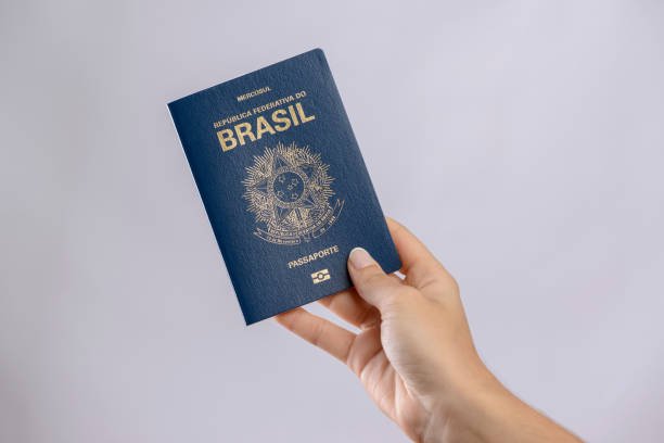 istock Brazilian passport in a hand with white background. 1417922711