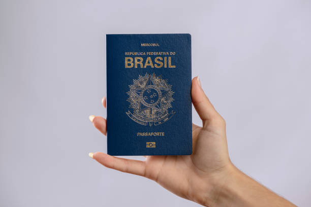 istock Brazilian passport in a hand with white background. 1417922717