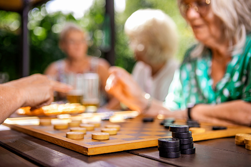 Small group of pretty senior women enjoying games together in the garden