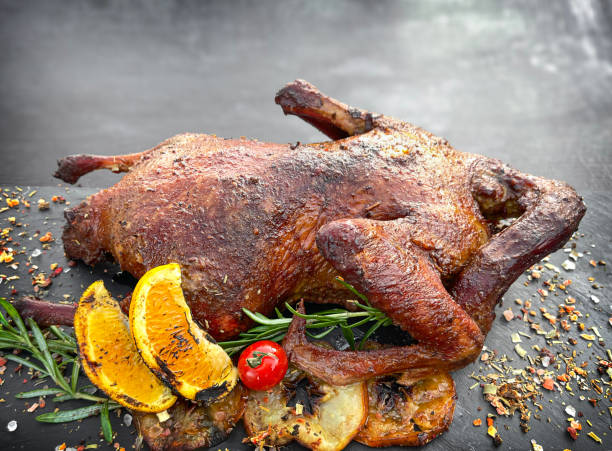 istock Roasted duck in a smoker grill on dark background. Copy space 1417928477