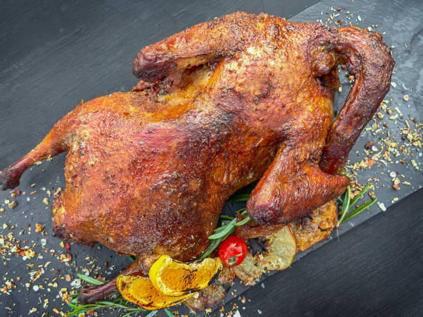 istock Roasted duck in a smoker barbecue on dark background. Top view 1417928579