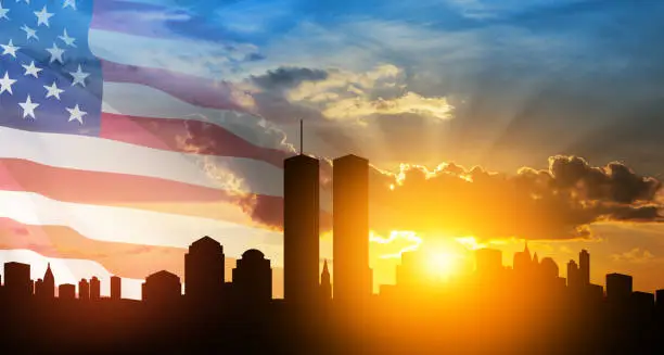 Photo of New York skyline silhouette with Twin Towers and USA flag at sunset. 09.11.2001 American Patriot Day banner.