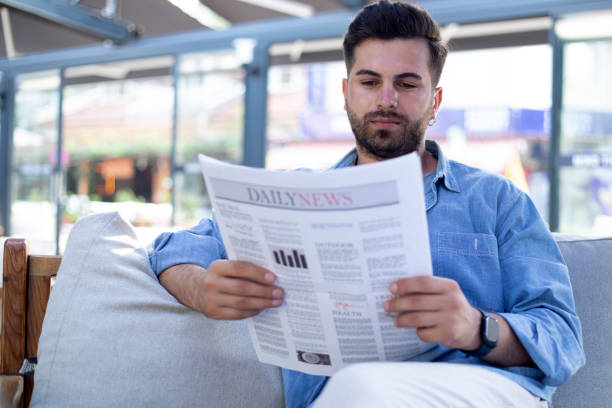 istock man reading newspaper at cafe 1417932365