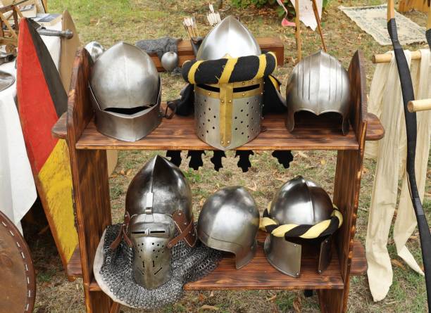 sei elmi da cavaliere medievale su uno scaffale di legno. - history knight historical reenactment military foto e immagini stock