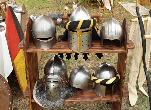 Group of  medieval knight helmets  on a wooden shelf.