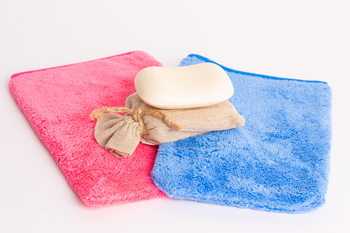 Bar of Soap on colorful Washcloths - white background - Sustainability Concept
