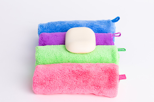 Bar of Soap on colorful Washcloths - white background - Sustainability Concept