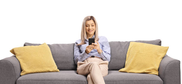 istock Woman resting on a sofa and typing on a mobile phone 1417940855