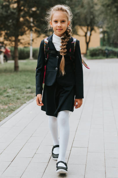 back to school. little happy kid pupil schoolgirl eight years old in fashion uniform with backpack and hairstyle voluminous long braid ready going to second grade first day at primary school - report card number 8 school education imagens e fotografias de stock