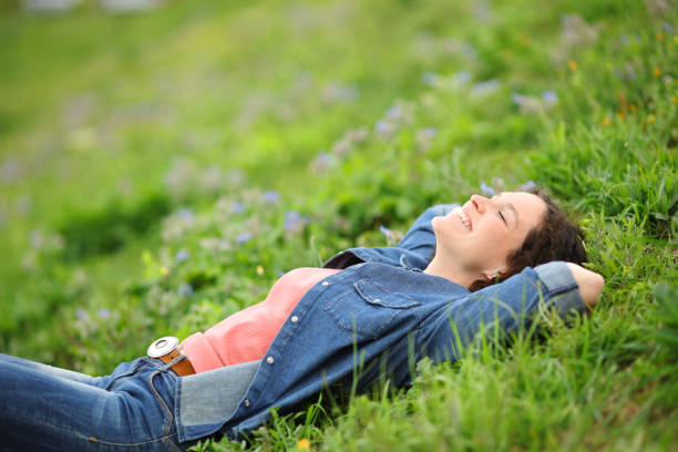 istock Woman lying on the grass in a park relaxing 1417943823