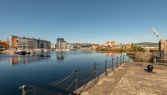 Modern buildings, boats and the wider harbour in Belfast's Titanic Quarter area