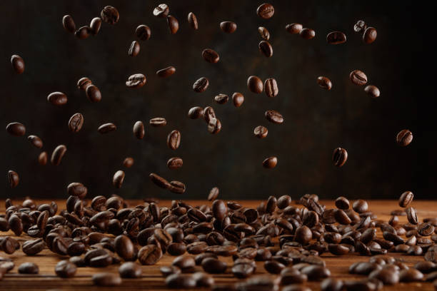 muchos granos de café tostados volando en el aire. - selective focus coffee coffee crop cafe fotografías e imágenes de stock