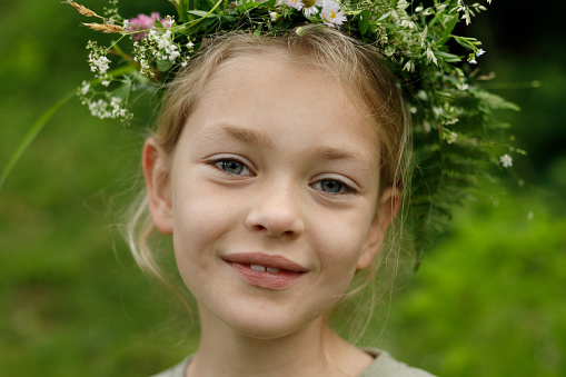 Slavic ritual on the equinox, portrait of a pagan child girl with a wreath on her head.