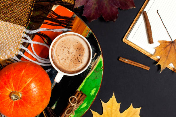 istock Opened notebook, pumpkin, cup of pumpkin cocoa or coffee, cinnamon, yellow autumn maple leaf, checkered plaid on black background top view copy space. Autumn flat lay background. Autumn, fall, halloween concept. 1417948030