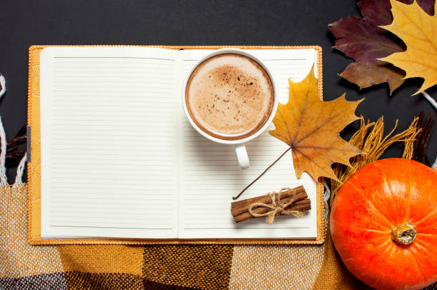 istock Opened notebook, pumpkin, cup of pumpkin cocoa or coffee, cinnamon, yellow autumn maple leaf, checkered plaid on black background top view copy space. Autumn flat lay background. Autumn, fall, halloween concept. 1417948033