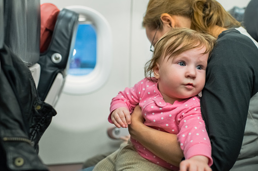 Mother with her baby traveling in airplane