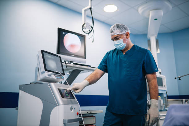 Doctor preparing medical equipment for the operation Image of a doctor preparing instruments and the medical room for the surgery. colonoscopy stock pictures, royalty-free photos & images