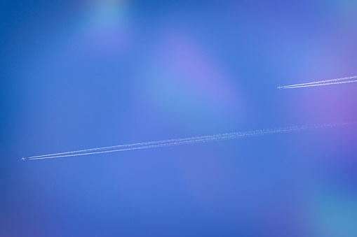 Two planes and their condensation trails in the sky on a summer day
