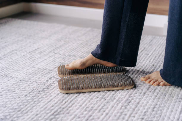 istock Barefoot female foot stands on a wooden board with nails for concentration practice 1417954813