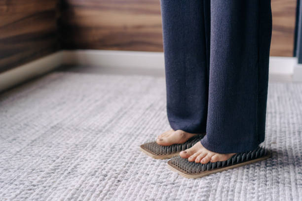 istock Barefoot female foot stands on a wooden board with nails for concentration practice 1417954817