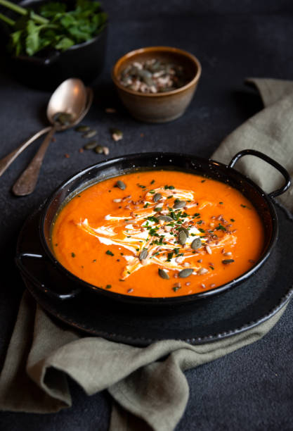 istock Pumpkin soup with cream and parsley in bowl 1417956516