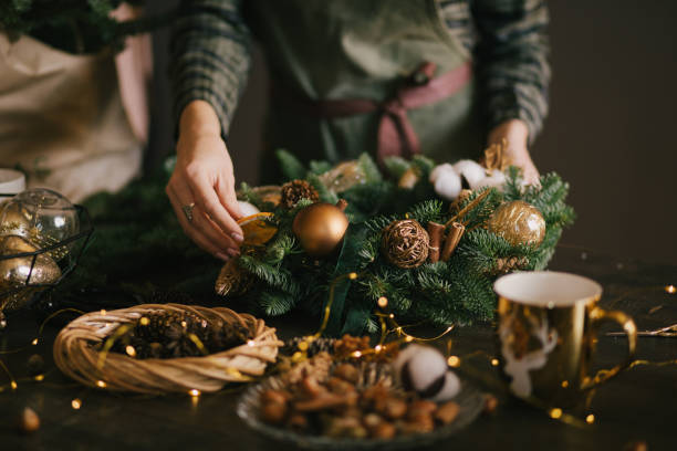 istock Millennial woman making Christmas wreath using pine branches and festive decorations in workshop. Small business 1417956649
