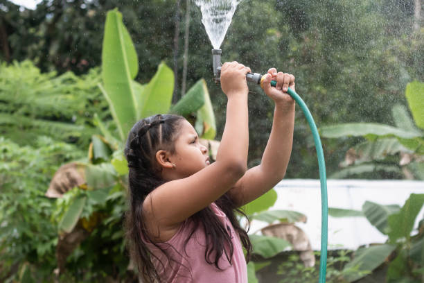 istock Little girl taking a bath and playing with a water hose 1417958265