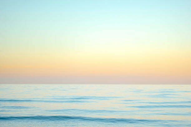 istock Pastel colored tropical sunset over horizon of light blue ocean 1417961005
