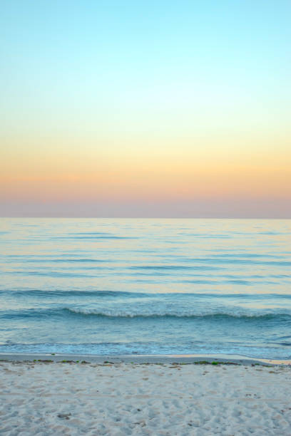 Tropical sea background with pastel colors with light blue, yellow and orange clear sky colored by the setting sun making soothing colors