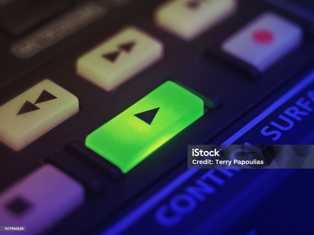 Highlighted play button of a professional music controller used on entertainment industry. Video or audio. A color graded, extreme close up shot with selective focus Movie Stock Photo