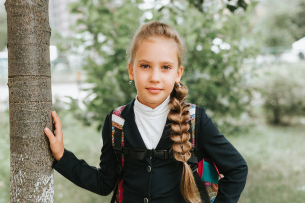 back to school. little happy kid pupil schoolgirl eight years old in fashion uniform with backpack and hairstyle voluminous long braid ready going to second grade first day at primary school - report card number 8 school education imagens e fotografias de stock