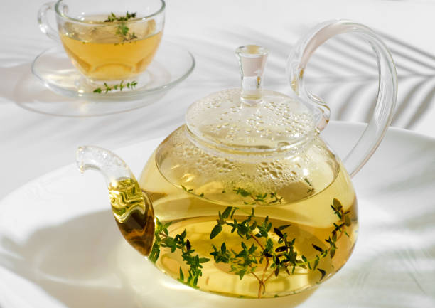 istock herbal tea with thyme in glass teapot. White background with copyspace. 1417965163