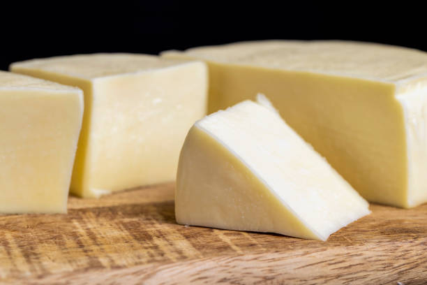 istock Fresh cow's milk cheese is cut on a board 1417970862