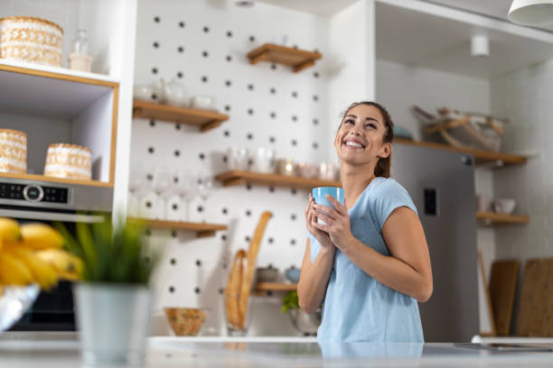 istock Happy woman drinking coffee in the kitchen 1417971806
