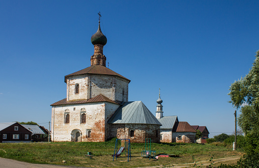 ancient white-stone Holy Cross Church on the grass on a bright sunny summer day in Suzdal Vladimir region