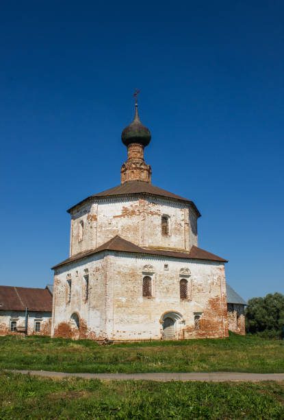 ancient white-stone Holy Cross Church on the grass on a bright sunny summer day in Suzdal Vladimir region