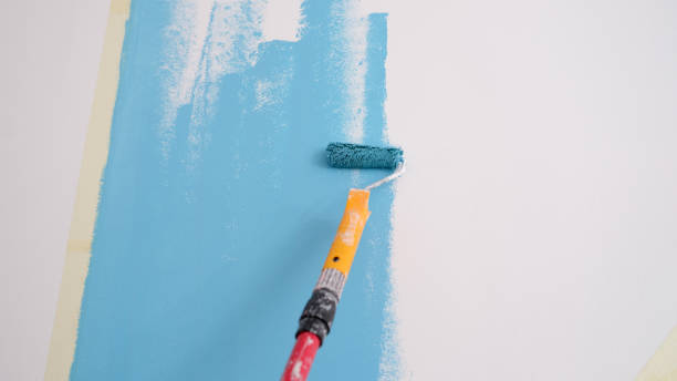 istock Hand painted wall. Painting walls with roller in blue 1417974077