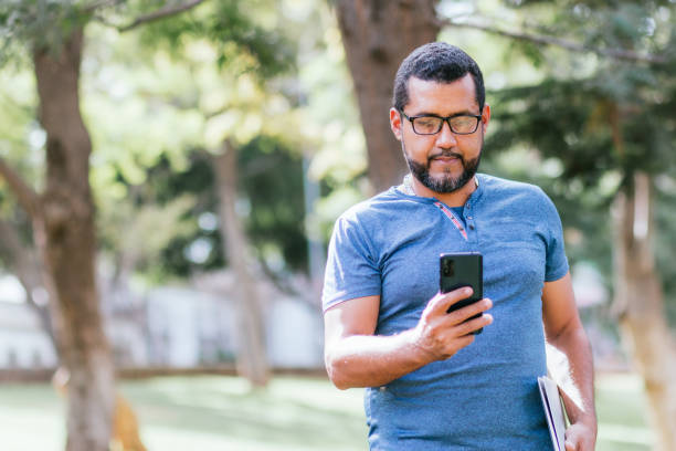 istock handsome businessman using his smartphone in park 1417974945